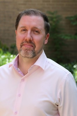 Man with dark hair and grey beard
