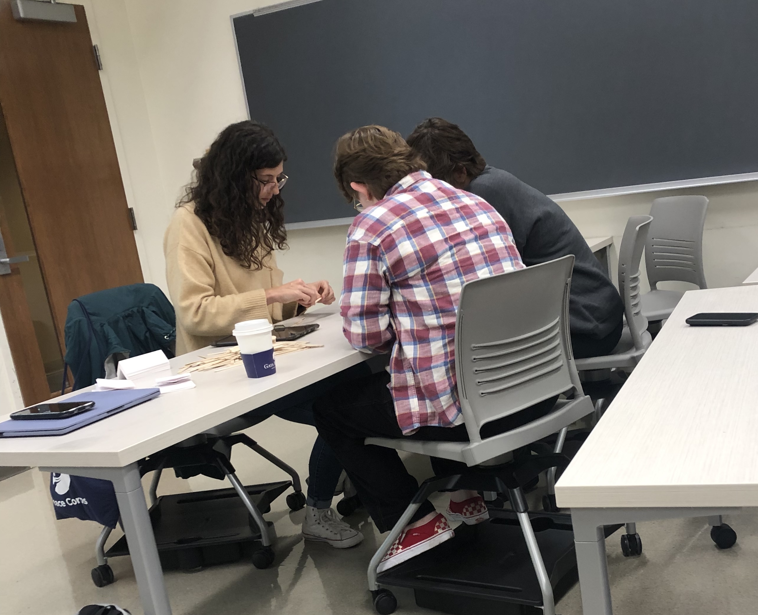Three students at a table working together on a project