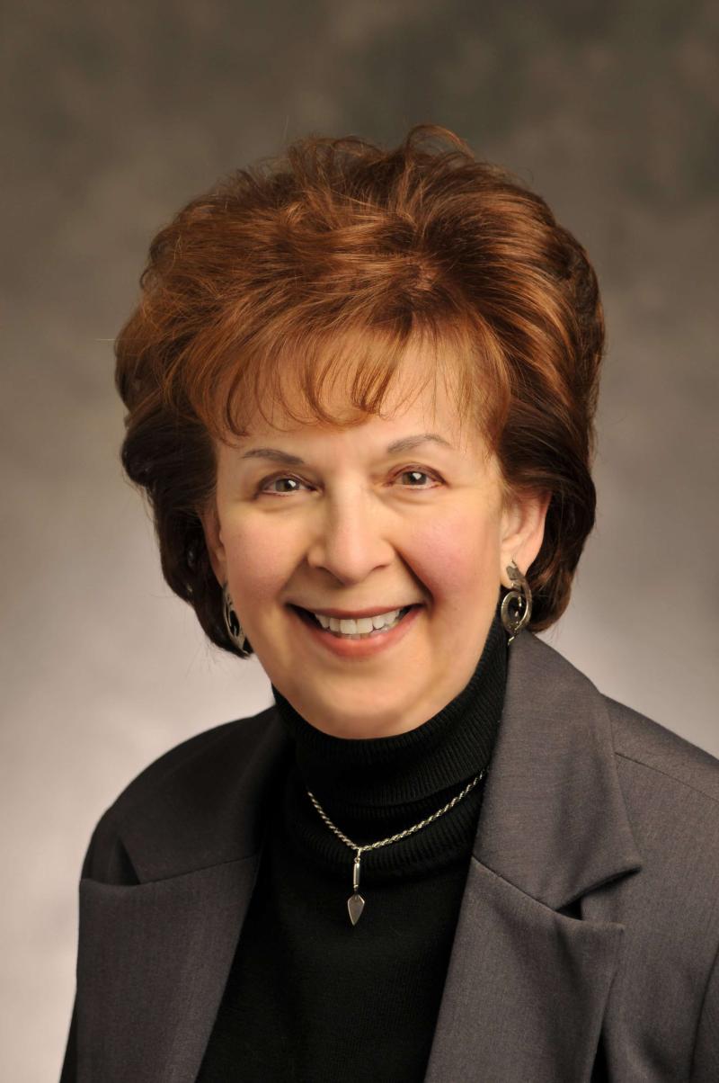 Woman with brown hair smiling at the camera