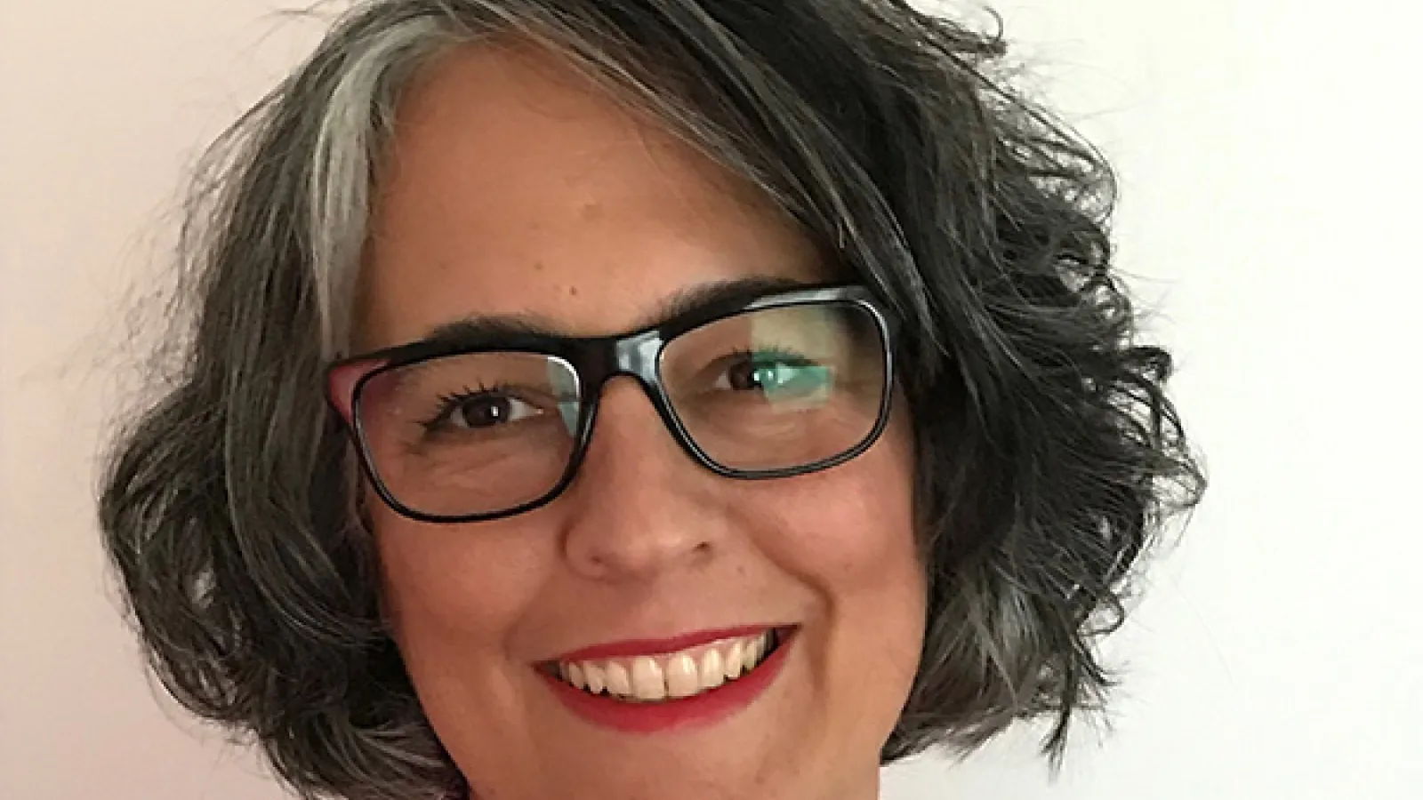 Smiling woman with dark hair and glasses
