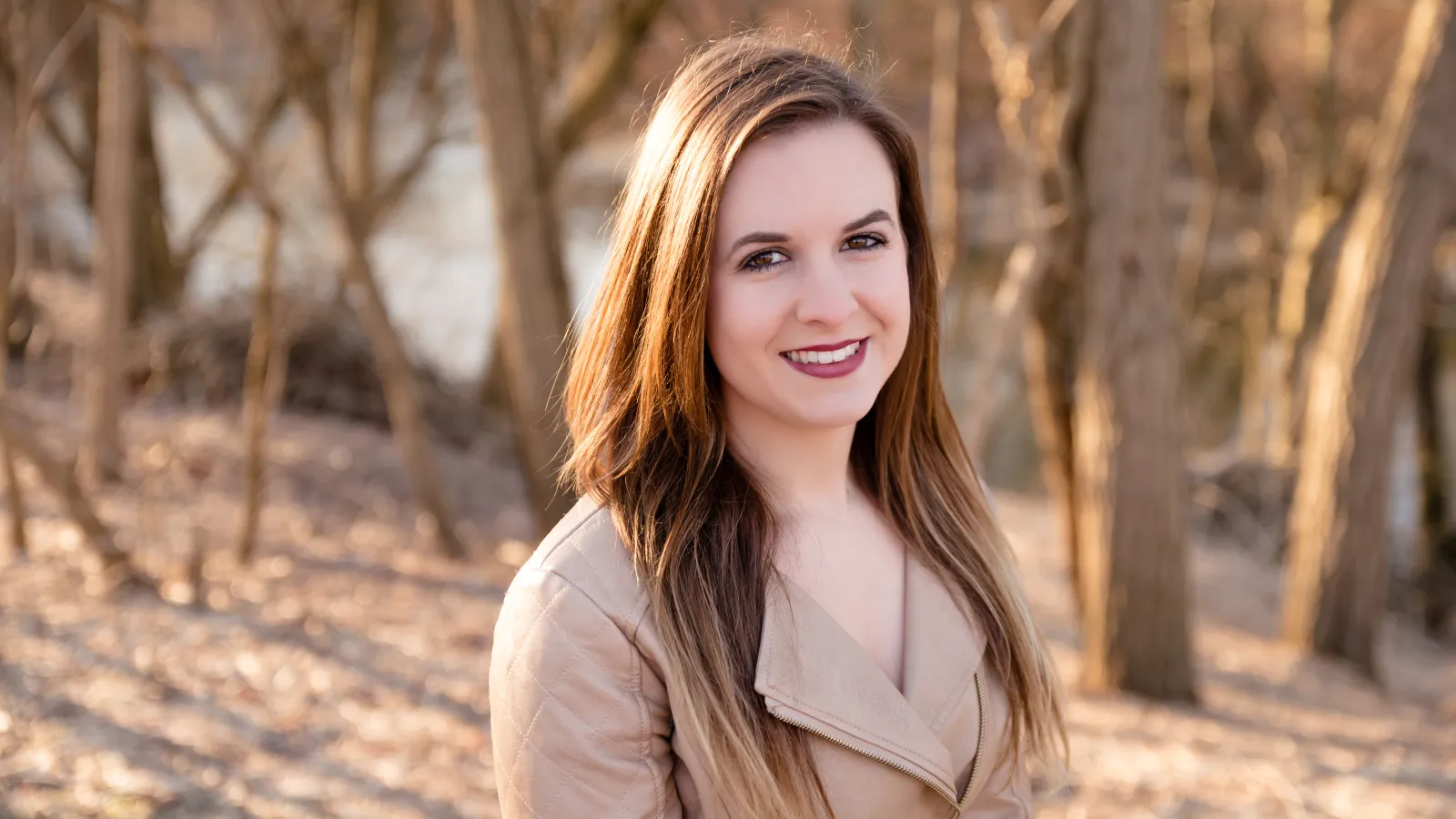 Woman with light brown hair standing in the woods