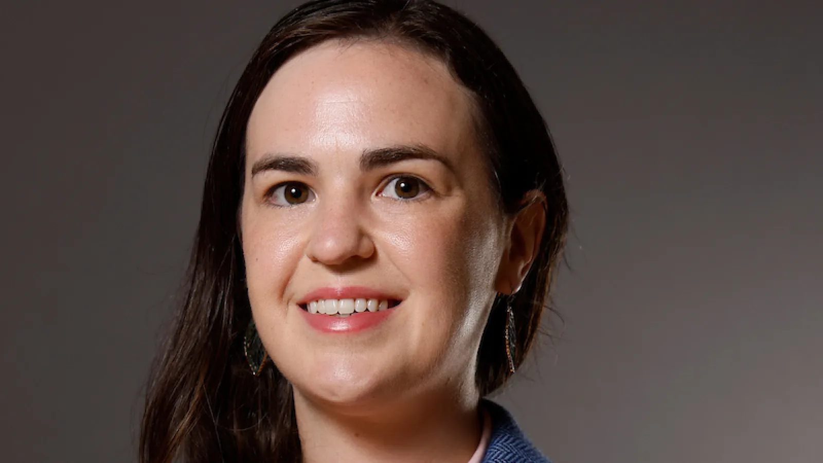 woman in a blue blazer and pink dress shirt