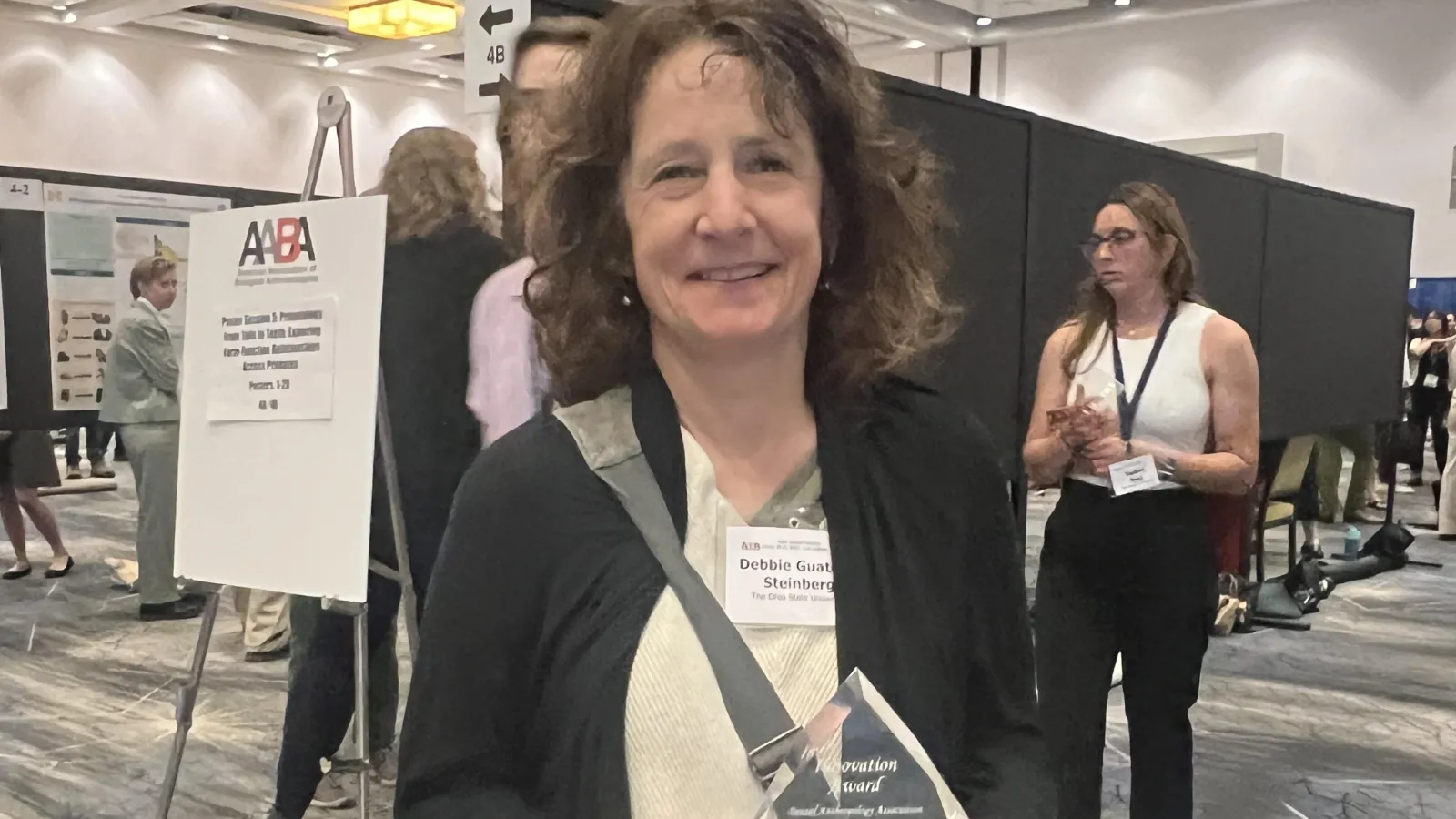 Smiling brunette woman holding a clear flame shaped award