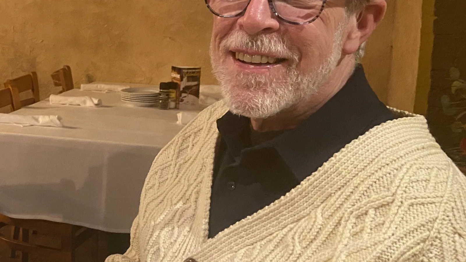 Smiling white man in glasses and a beige sweater