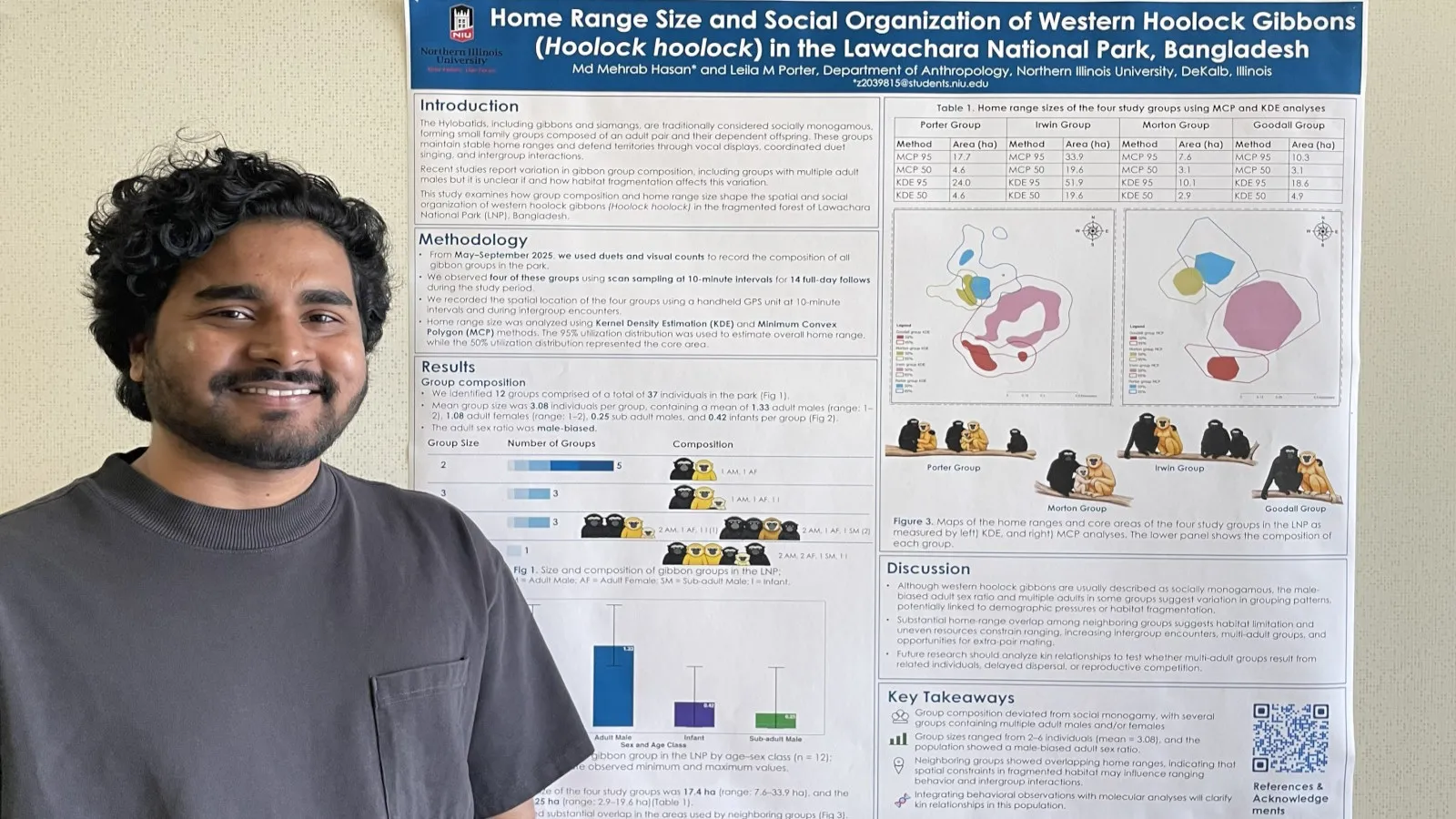 DArk skinned man with short dark hair standing in front of a scientific poster