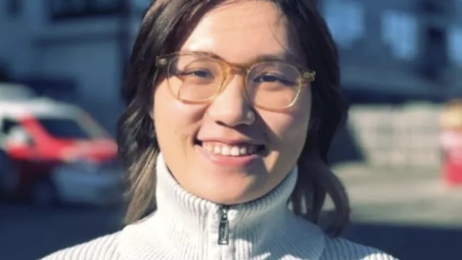 Headshot of a young asian woman smiling with glasses
