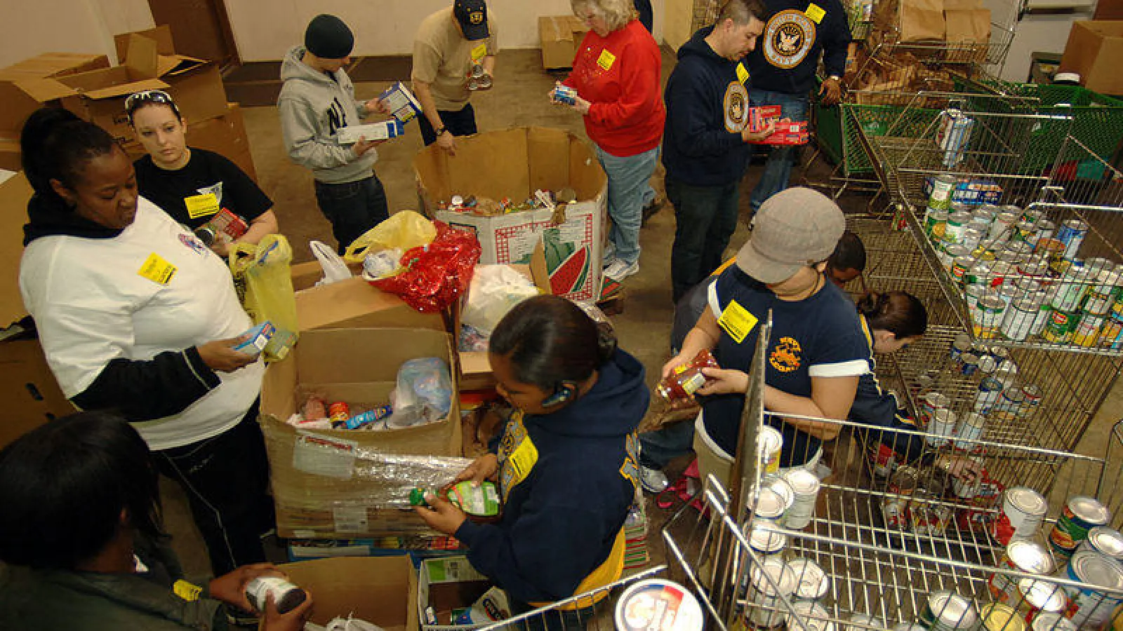 U.S Navy sailors check canned foods at a food bank 