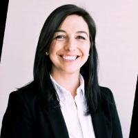 Smiling black haired woman in black suit