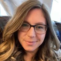 Woman with long dark blonde hair and glasses