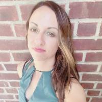 Long haired brunette woman wearing a teal shirt