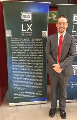 Dr. Fargher standing in front of banner