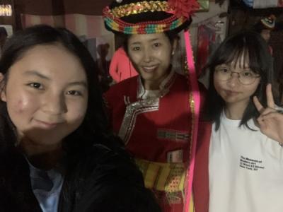 2 Chinese women standing with another woman in traditional Mosuo dress