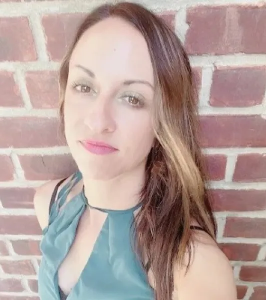 Long haired brunette woman wearing a teal shirt