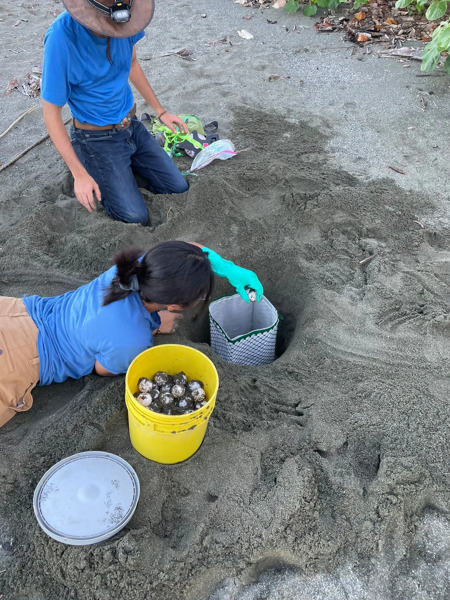 student lying on their stomach, reaching onto a pit