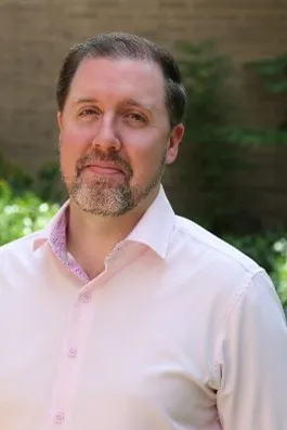 Man with dark hair and grey beard