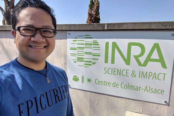 Man standing next to a sign reading INRA Science and Impact