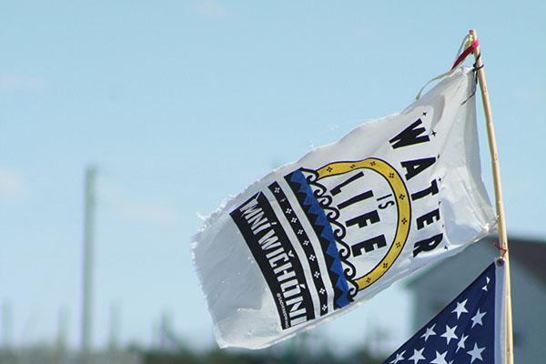 An image of a flag that reads "Water is Life"