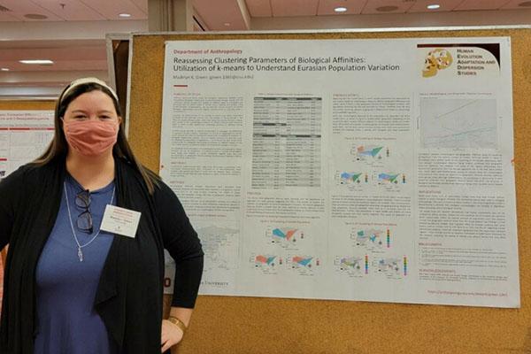 A photo of Maddie presenting her poster