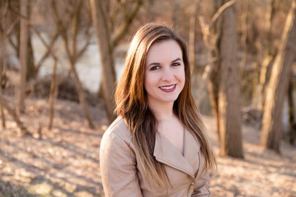 Woman with light brown hair standing in the woods