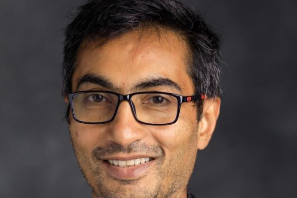 Smiling dark haired man with glasses