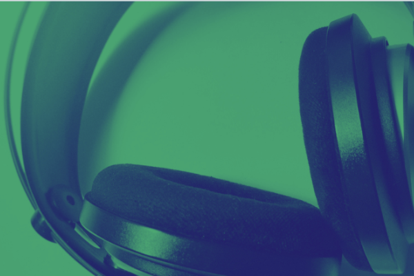 a pair of over-ear headphones in dark blue against a green background