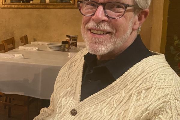 Smiling white man in glasses and a beige sweater
