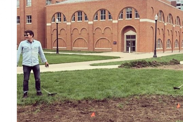 Dr. Kawa stands in front of biosolids on the university campus