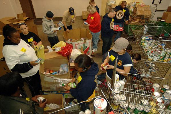 U.S Navy sailors check canned foods at a food bank 