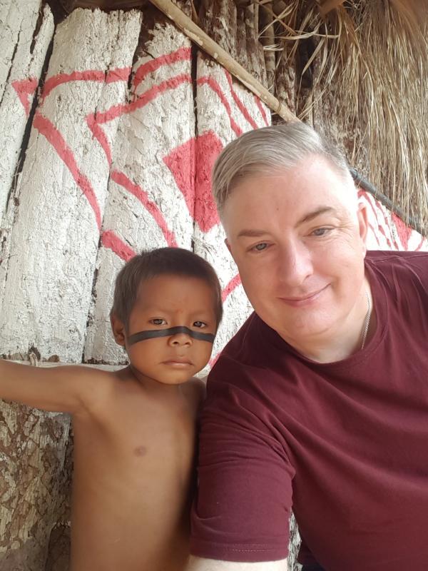 Grey haired man with toddler who has paint across his nose and cheeks