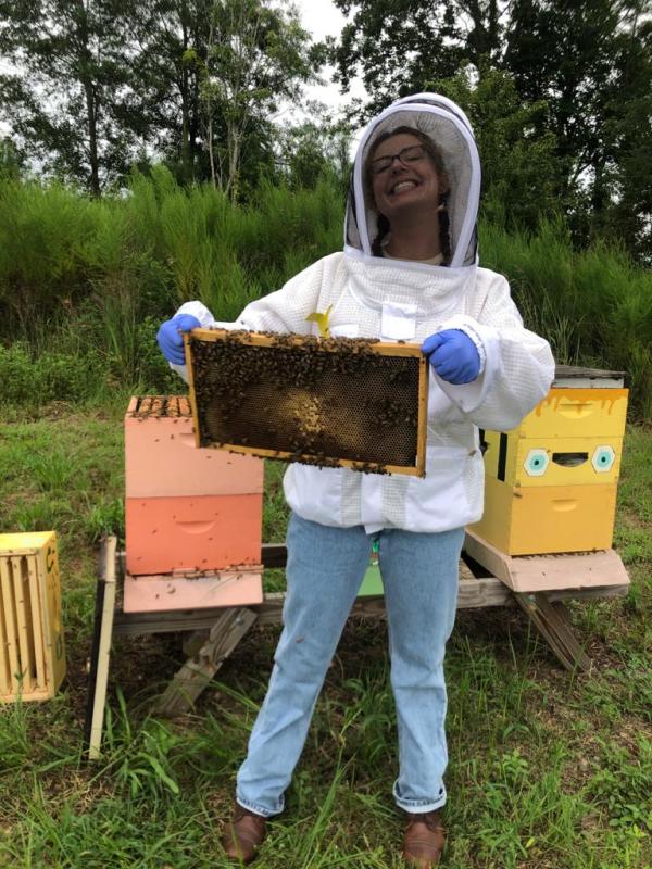 Maddison Elliott in a beekeeping suit taking care of bees