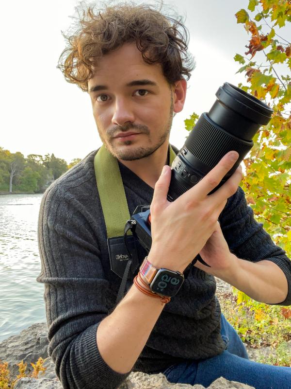(Steven Rhue) Young man with brown hair holding a camera