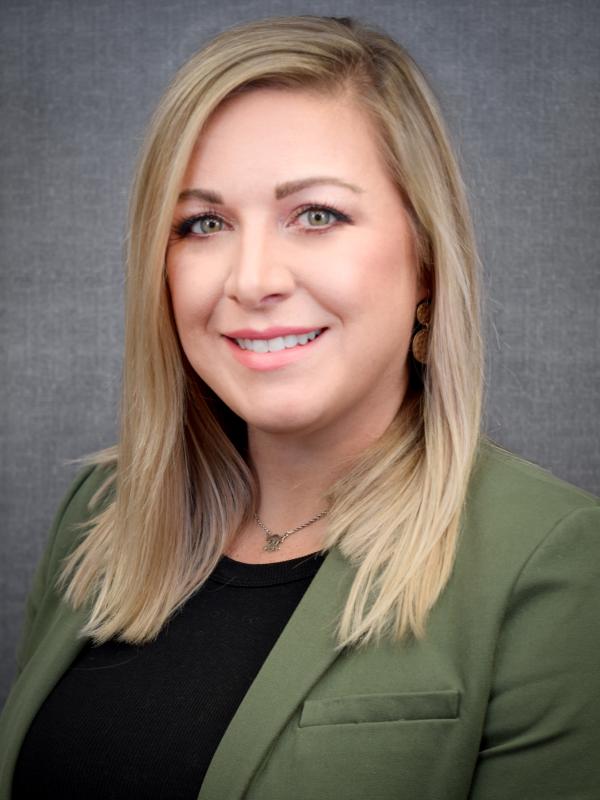 Photo of blond woman wearing a green blazer