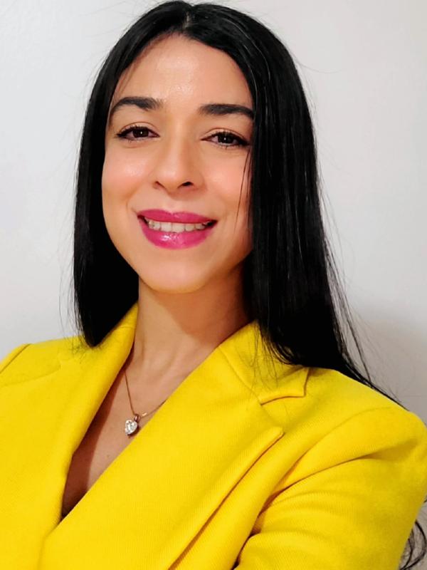 Woman with long dark hair wearing a yellow jacket