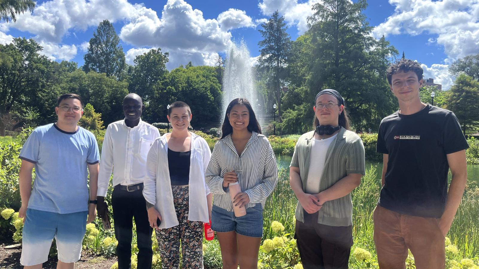 5 new graduate students smiling at the camera