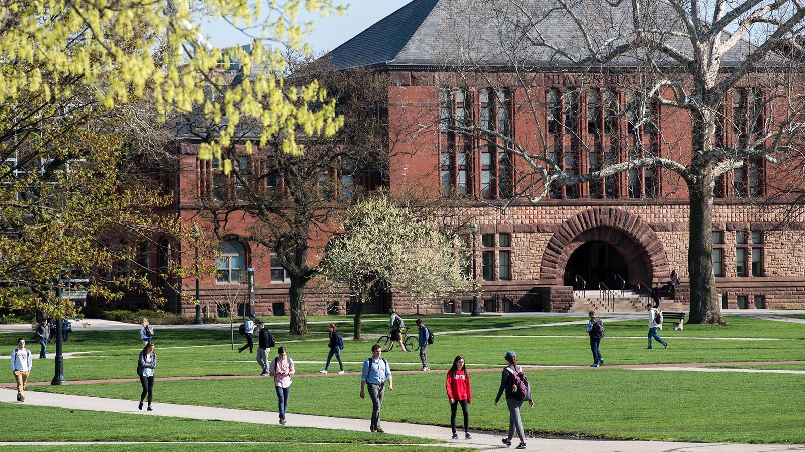 Students walking in front of brick campus building