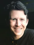 Dark haired man smiling into the camera